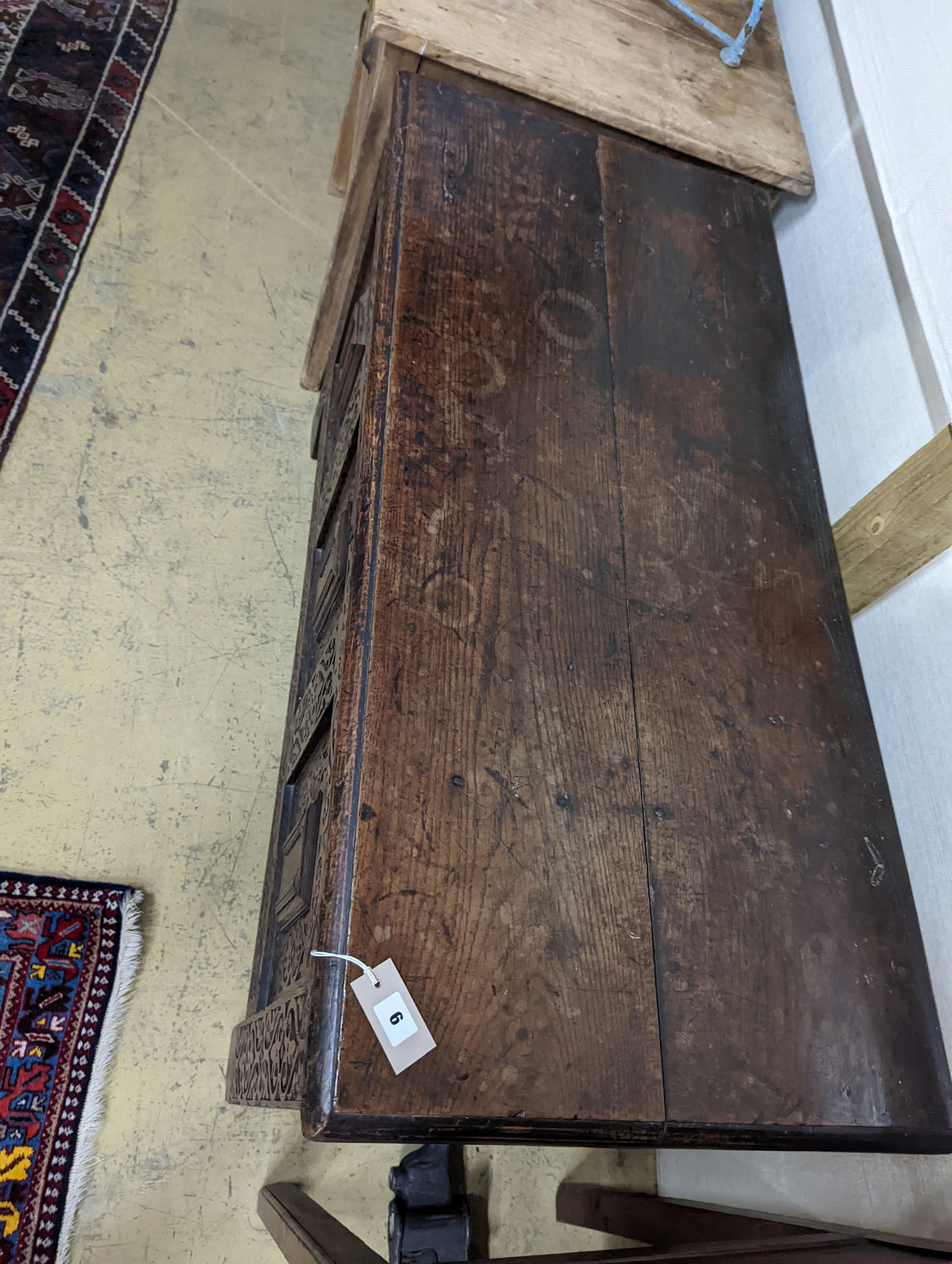 A 17th century carved oak coffer. W-124cm, D-56cm, H-72cm.